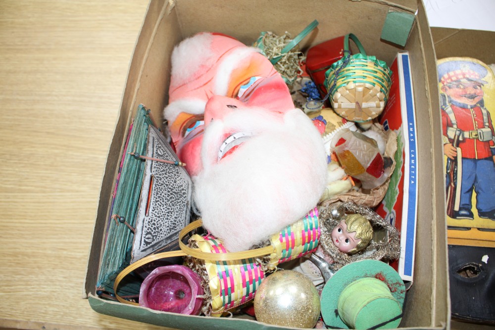 A collection of assorted curios, mostly vintage Christmas decorations but including masks and paper cut-outs